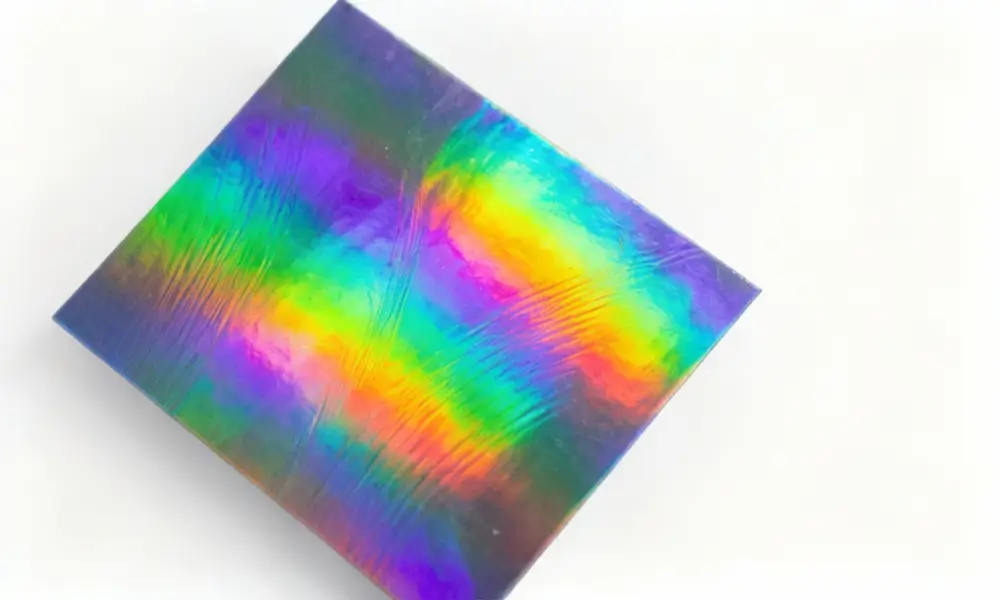 Custom holographic sticker showing rainbow diffraction effect on metallized polyester film