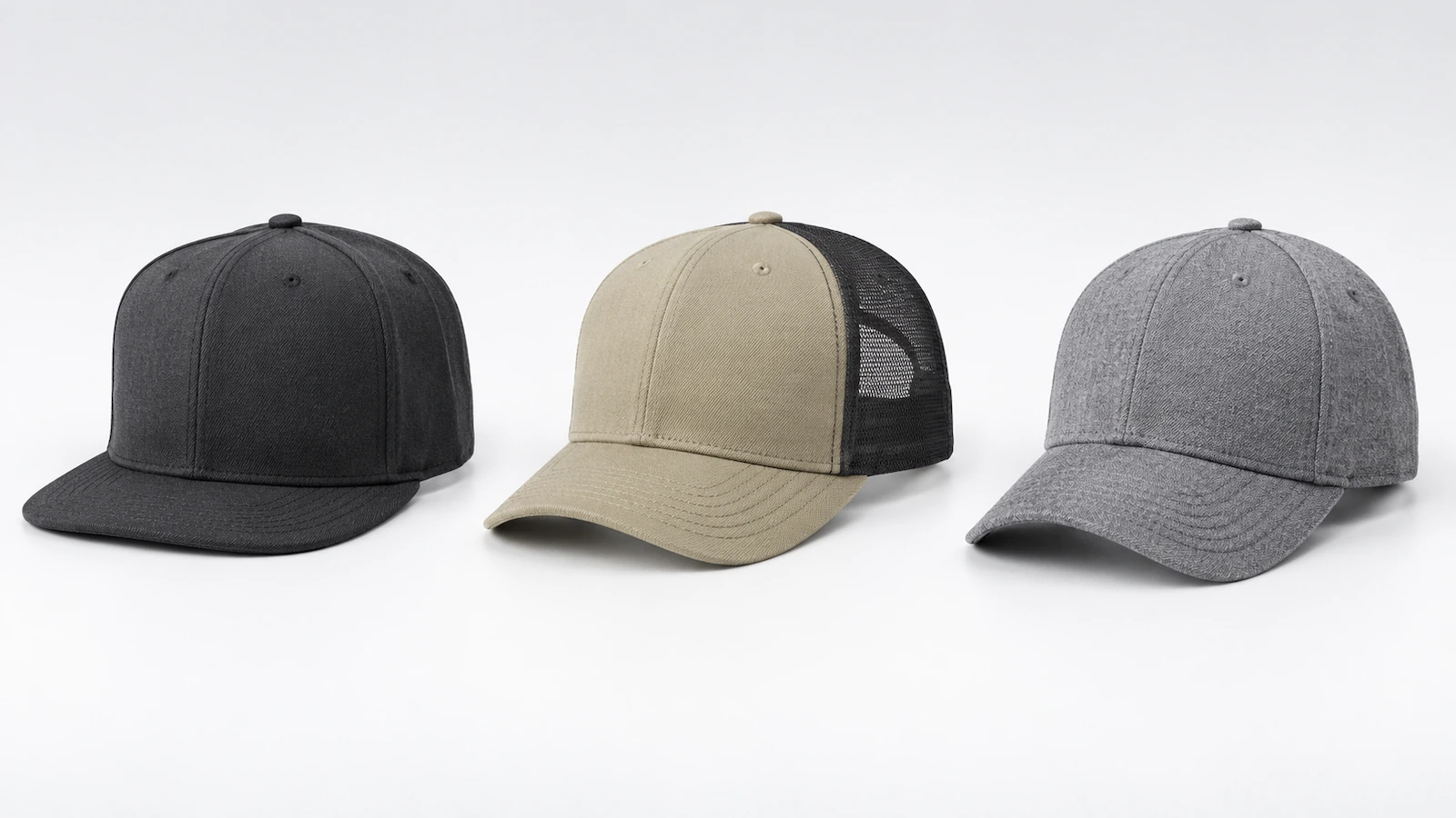 Tre cappellini lisci affiancati: un fitted a calotta alta con visiera piatta, un trucker a profilo medio con retro in rete e un cappellino strutturato a 6 pannelli privo di qualsiasi marchio