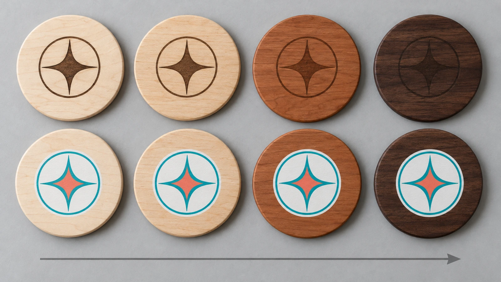 Fila di sottobicchieri tondi in legno, dall'acero chiaro al noce scuro, tutti decorati con lo stesso emblema astratto: il contrasto dell'incisione si attenua sul legno più scuro, mentre il colore stampato resta visibile