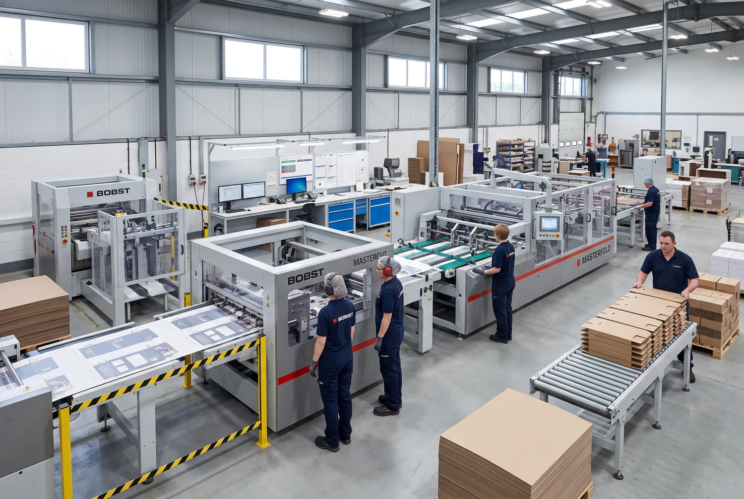 Operai accanto a macchine per la lavorazione del cartone e pile di cartoncino piano in una fabbrica