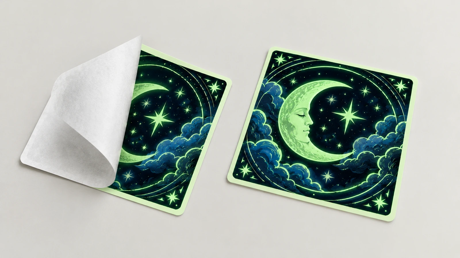Due adesivi quadrati con luna e stelle, uno con il supporto di carta bianca parzialmente staccato
