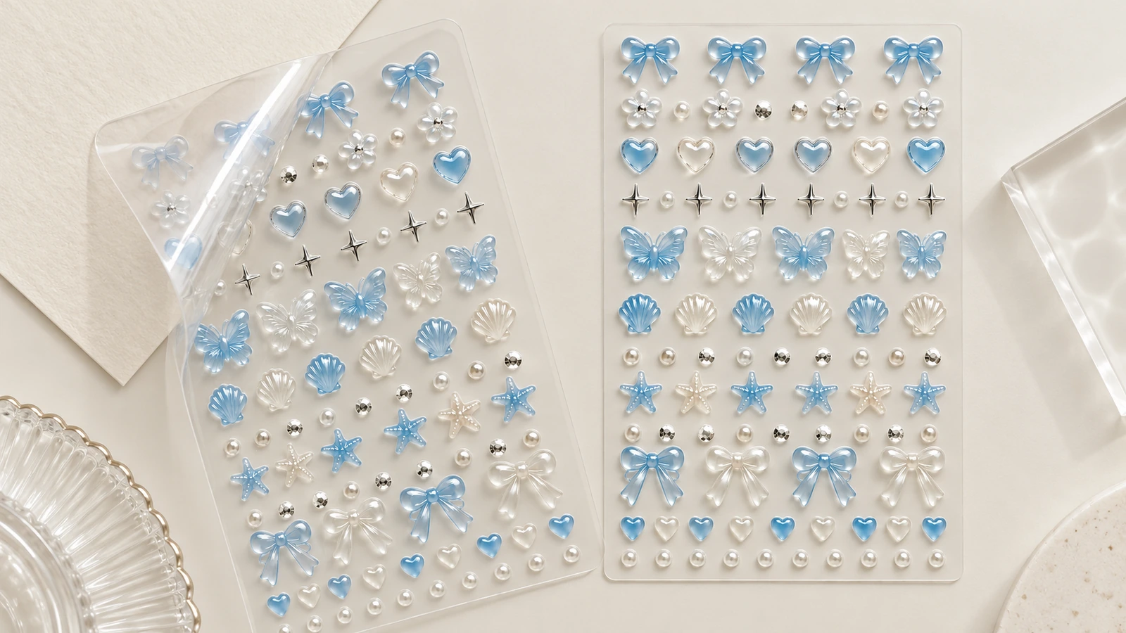 Due fogli trasparenti con fiocchi blu, cuori, conchiglie e decorazioni per unghie color perla