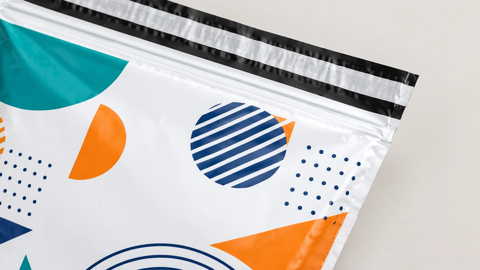 Primo piano illustrato di grafica geometrica e strisce nere parallele lungo la parte superiore di un mailer