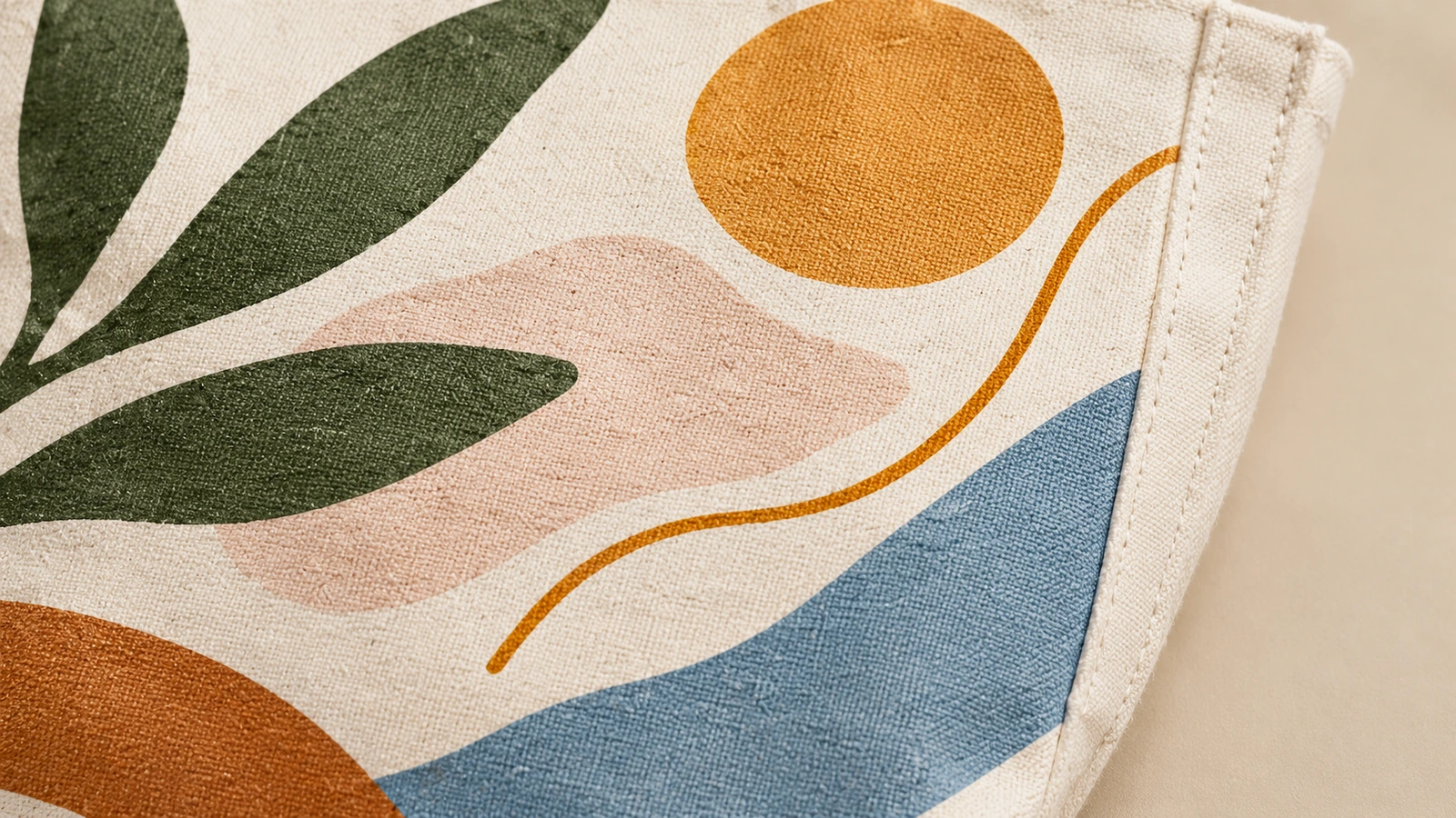 Dettaglio della stampa e della cucitura della borsa tote in cotone Primo piano della grafica con foglie e motivi astratti su tessuto di cotone accanto a un bordo cucito