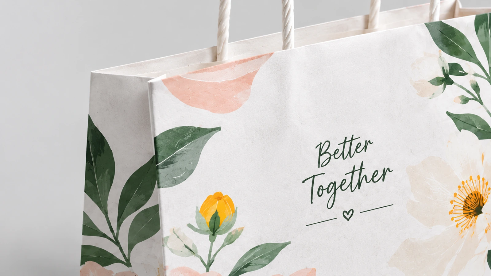 Primo piano della stampa floreale, della scritta Better Together e dei manici ritorti in carta
